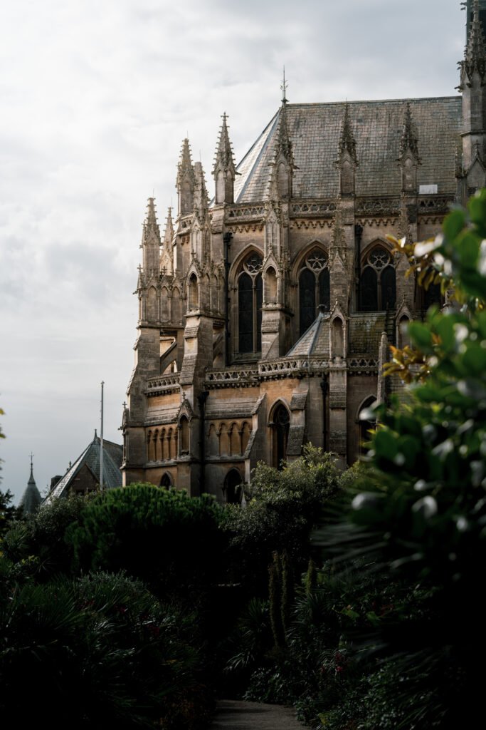 A vertical shot of the Arundel castle and cathedral surrounded by beautiful foliage, during daylight